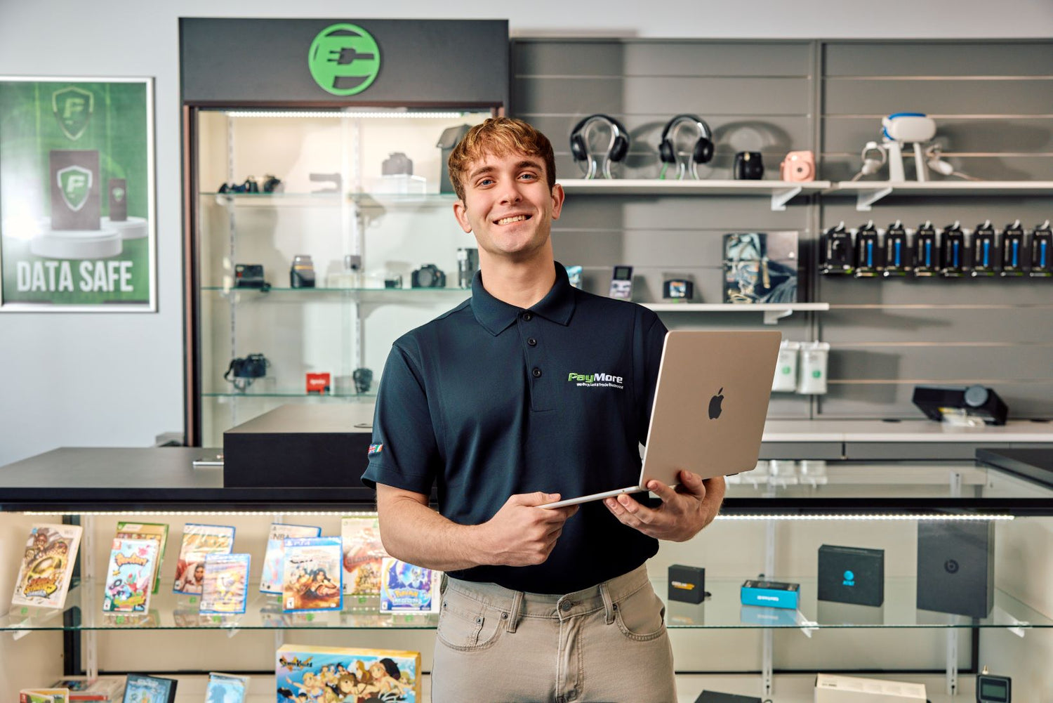 employee smiling and holding a laptop